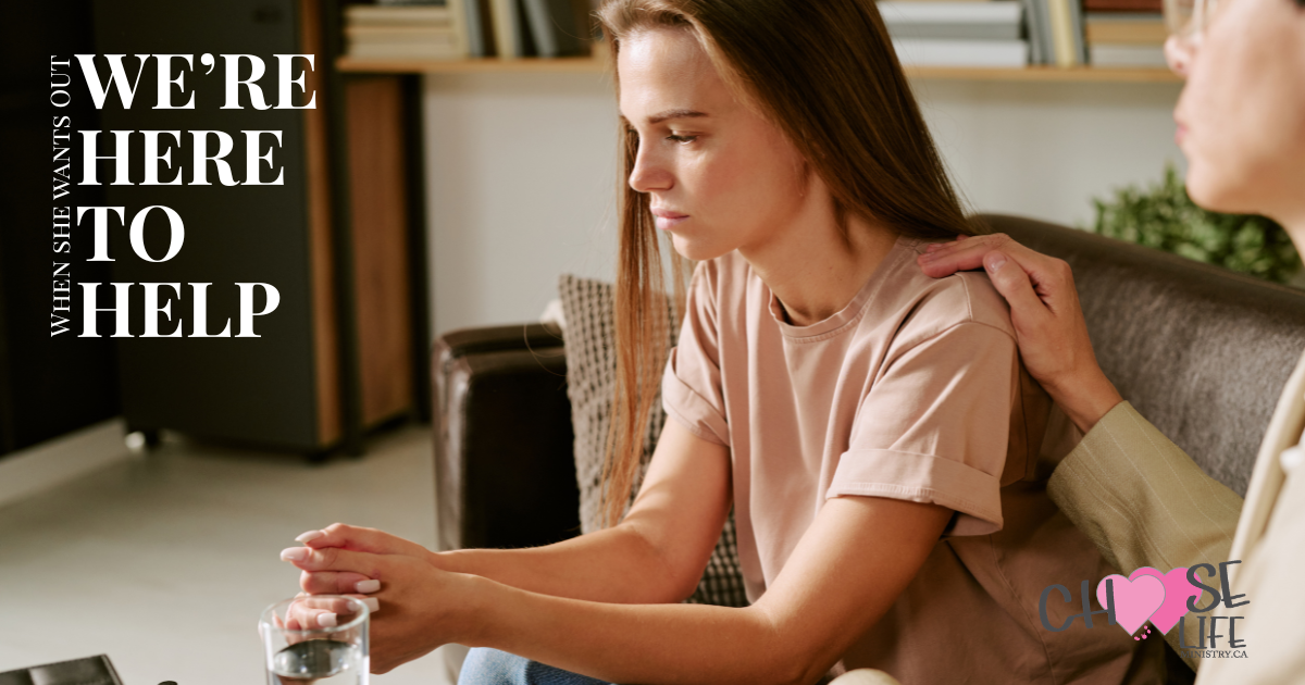 A compassionate woman comforting another woman struggling — When she wants out, we're here to help.